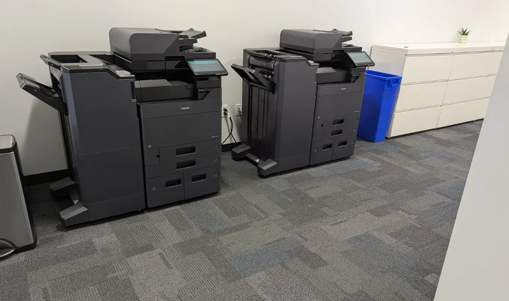 Two Kyocera multifunction printers installed side by side in a client office